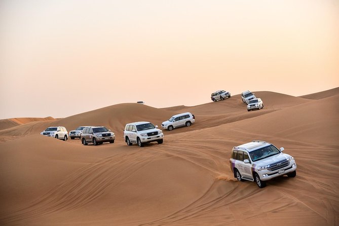 Dubai Desert Safari with BBQ And 4W Land Cruiser Dune Bashing Experience - Riding across the dunes in a Land Cruiser